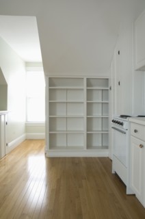 Empty room in apartment with hardwood floor and bookcase