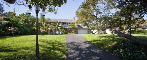Lawn with driveway leading to multiple story home