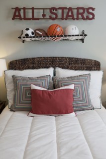 Balls over arranged pillows on tidy bed in the bedroom at home