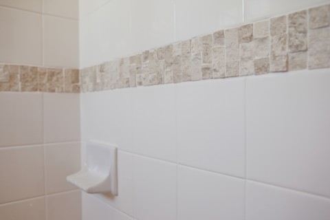 Close-up of a soap dish on tiled bathroom wall at home