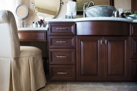 Chair with brown cabinets and mirrors in bathroom at home