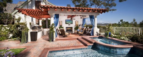 Sitting area at covered patio with swimming pool in foreground