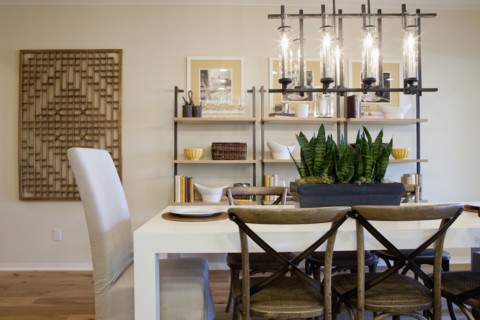 Chairs at dining table with shelves in the background at home
