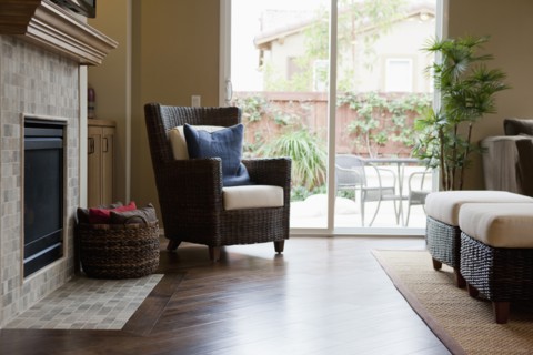 Wicker armchair and basket by mantelpiece in living room