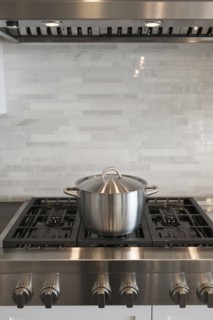 Sauce pan on stove against backsplash in kitchen