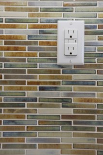 Close-up of tile backsplash with electrical socket