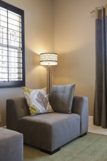 Lit floor lamp by couch in living room