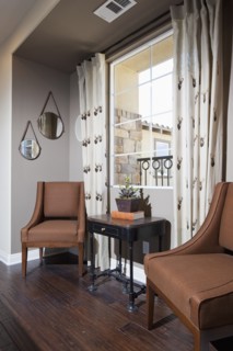 Brown chairs and end table against window