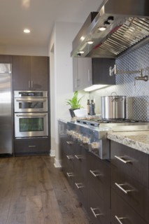 Kitchen having brown cabinets with vent hood at home