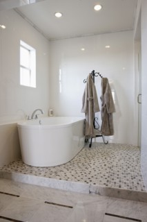 View of a bath with bathrobes on stand in the bathroom