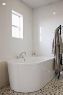 View of a bath with bathrobe on stand in the bathroom