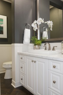 White cabinets and washbasin with commode at a distance in the bathroom at home