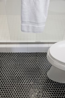 Mosaic floor with cropped commode and glass shower in the bathroom at home