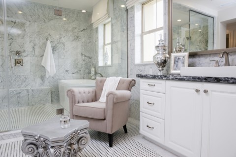 Sitting area with bathtub across the glass wall in the bathroom