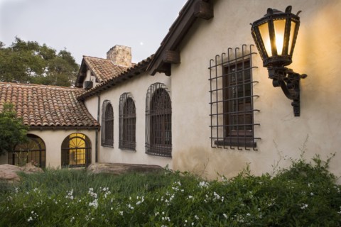 Row of windows with wrought iron grills on side of spanish style home