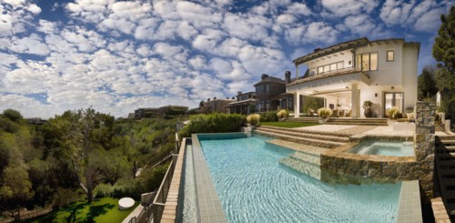Swimming pool behind multiple story contemporary home