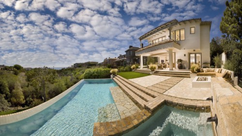 Swimming pool behind multiple story contemporary home