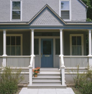 Front porch of gray stucco house with dark blue trim