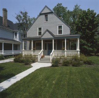 Facade of a gray stucco house with white and dark blue trim