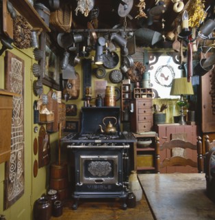 Old tin kitchen utensils and molds hanging from ceiling in country kitchen
