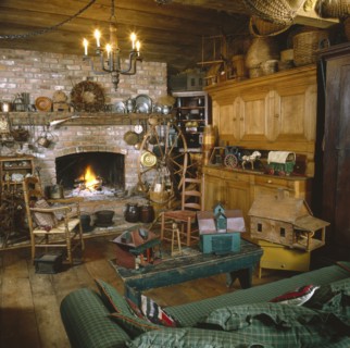Toy house on coffee table with candle lit chandelier in rustic living room