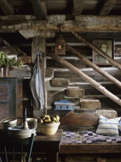Rustic stairs descending into kitchen area in restored log home