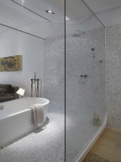 Modern bathroom inside bedroom with glass wall