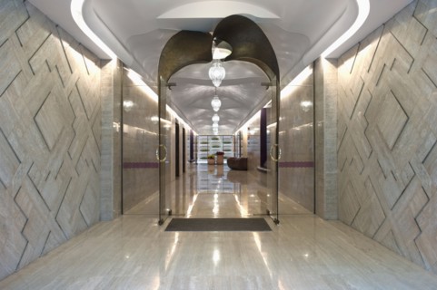 Long marble hallway with double glass doors at end