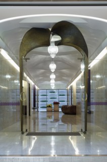 Long marble hallway with double glass doors at end