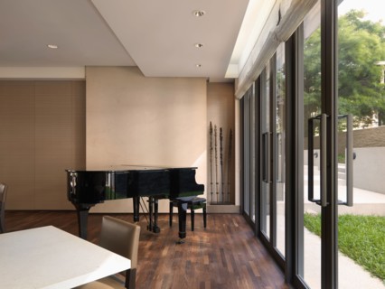 Baby grand piano in corner near double glass doors