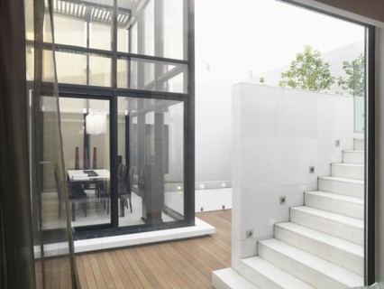 White staircase leading to deck and glass dining room