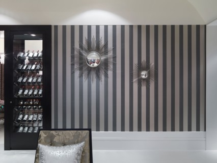 Striped wall with decorative mirrors and wine cooler
