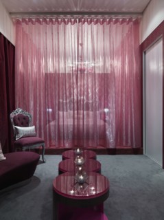 Chic bedroom with pink glass coffee table and grey carpet