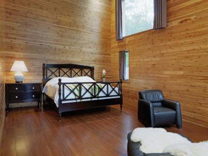 Master bedroom with black leather chair in cabin home