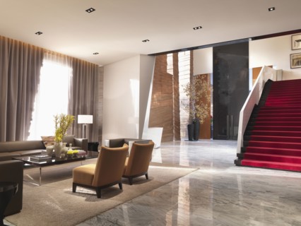 Sitting area and grand red staircase in modern interior