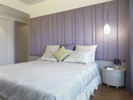Bed with pillows and purple headboard
