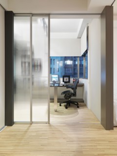 Modern home office with hardwood floor and sliding glass doors