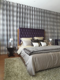 Elegant modern bedroom with purple velvet headboard