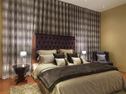 Elegant modern bedroom with purple velvet headboard