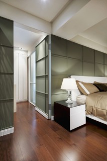 Brown bed in modern bedroom with green accent wall