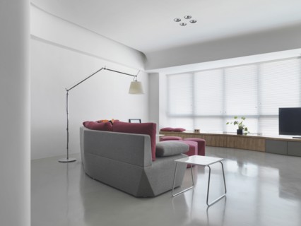 Gray sofa in living room with several windows