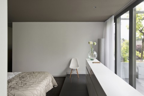 View of a cropped bed along large window in bedroom at contemporary house