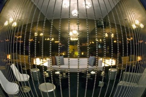 Fisheye view of lounge area behind beaded curtain in nightclub