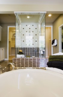 Image of bathtub and towels with shower in background.