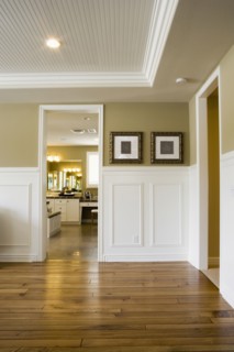 Image of empty room with wood floor looking into another room.