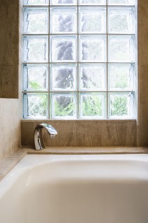 Detail of bathtub and cubed glass window.