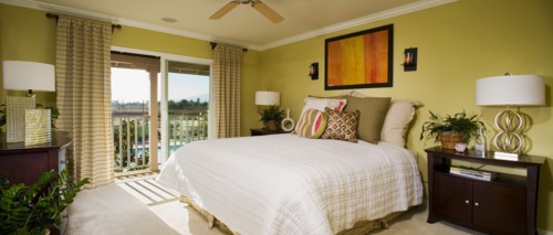 Green master bedroom with sliding glass doors