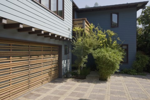 Wooden garage door and blue sided home