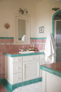 Bathroom sink and counter in pink and teal tiled bathroom