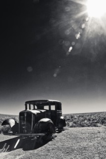 Vintage car missing tires in remote field